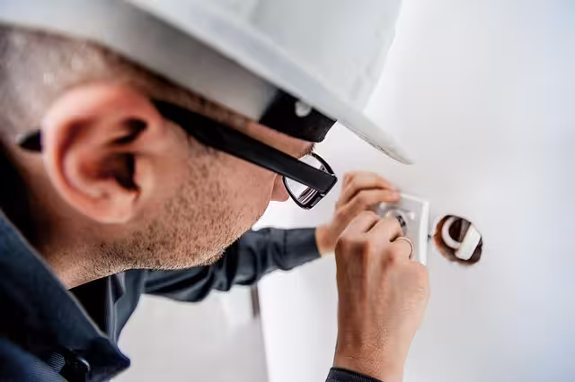 An electrician looking at an outlet.