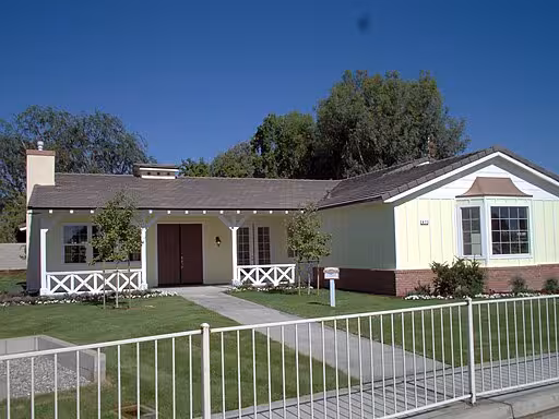 A yellow ranch house in a suburban area.