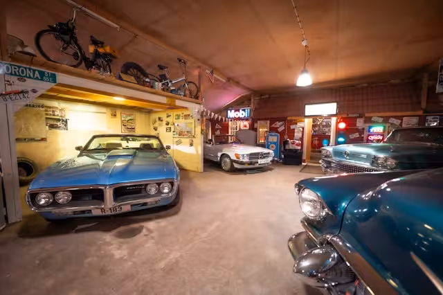 Various vintage cars in a garage.