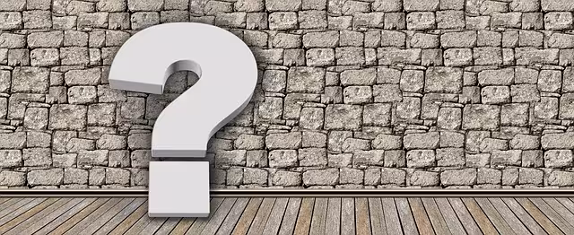 A question mark by a stone wall.