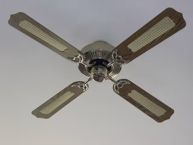 A brown ceiling fan with golden fixture.