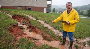 A man assessing the flow of water on a property.