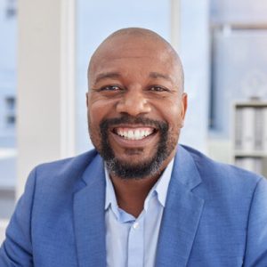 A man smiling in blue suit.