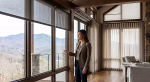 A woman looking at window treatments for large windows.